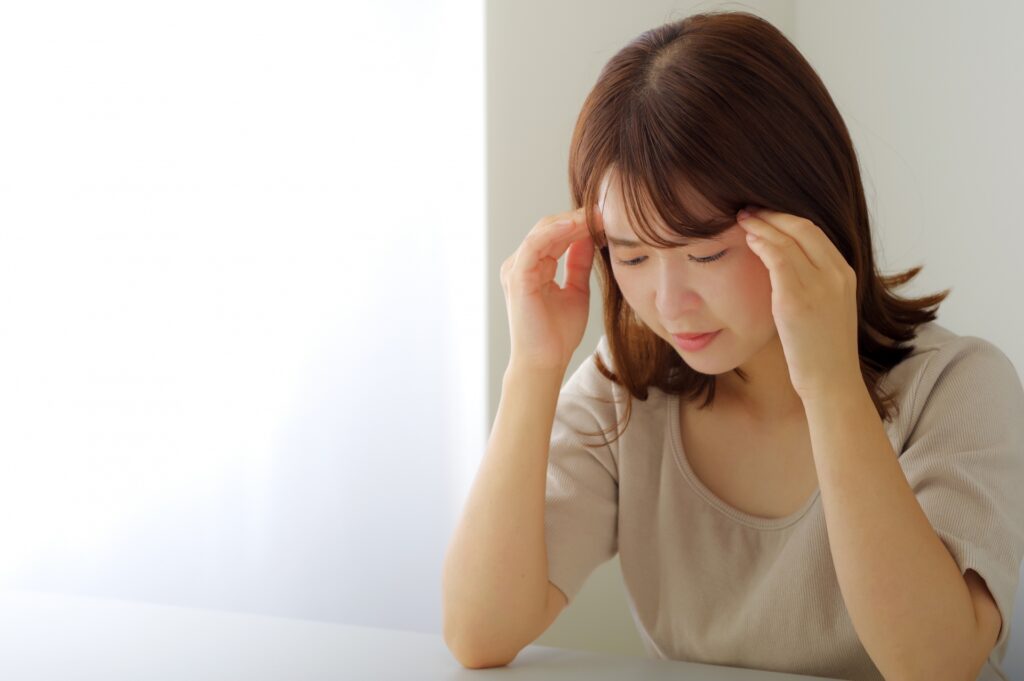 後頭神経痛で頭を押さえる女性：八広駅前整骨院の写真